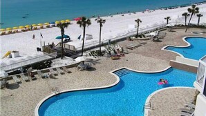 Un complexe hôtelier doté d’une piscine, d’une plage et offrant une vue sur l’océan.