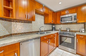 A kitchen with wooden cabinets, a stainless steel microwave, a Bosch oven, and a dishwasher.
