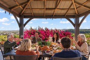 A group of people dining at an outdoor table with a view of the countryside. - Wine Country Villa with Panoramic Views (Fairfield)