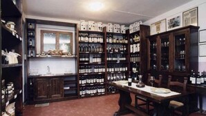 A wine cellar with wooden shelves and cabinets, a dining table, and a window.