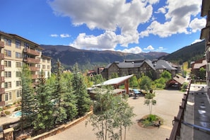 Experience the serene mountain views from the resort's spacious balconies and enjoy a refreshing dip in the pool surrounded by lush trees.