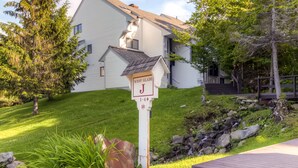 A residential house with a well-maintained lawn, a mailbox, and a stone pathway leading to the entrance.