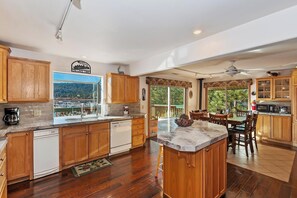 Enjoy meals in the kitchen with a dining area and appliances, offering a view of the surrounding landscape and mountains.
