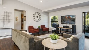 A modern living room with a sofa, chairs, a coffee table, and a TV. - PRIVATE TENNIS + SEPARATE PICKLE COURT, HUGE HEAT POOL, SHUFFLEBOARD, PUTT GOLF! (Scottsdale)