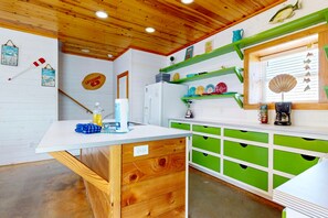 A kitchen with wooden cabinets, a white countertop, and a green backsplash. - Pet Friendly, Close to beach, Shared Pool, Golf Cart Access (Port Aransas)