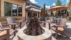 An outdoor patio with Adirondack chairs, a fire pit, and umbrellas. - Tl2210 Perfect for A Couple! Winter Specials!! Many Outdoor Activities! (Steamboat Springs)