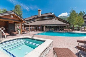 A hotel with a swimming pool, lounge chairs, and a covered area with a wooden deck. - Tl2210 Perfect for A Couple! Winter Specials!! Many Outdoor Activities! (Steamboat Springs)