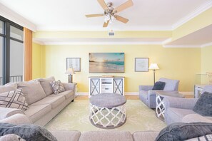 A living room with a ceiling fan, two sofas, a coffee table, and a TV.