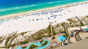 Un resort frente al mar con piscina, sombrillas de playa y un paseo marítimo.