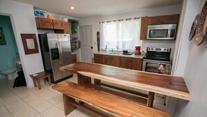 A kitchen with a wooden bench, a refrigerator, a microwave, and a stove. - All About Location! Perfect, Well Equipped Condo 300 Yards From Beach, 2 Pools (Tamarindo)