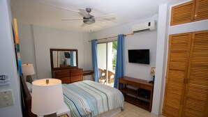 A bedroom with a bed, a desk, a chair, a TV, and a wardrobe. - All About Location! Perfect, Well Equipped Condo 300 Yards From Beach, 2 Pools (Tamarindo)