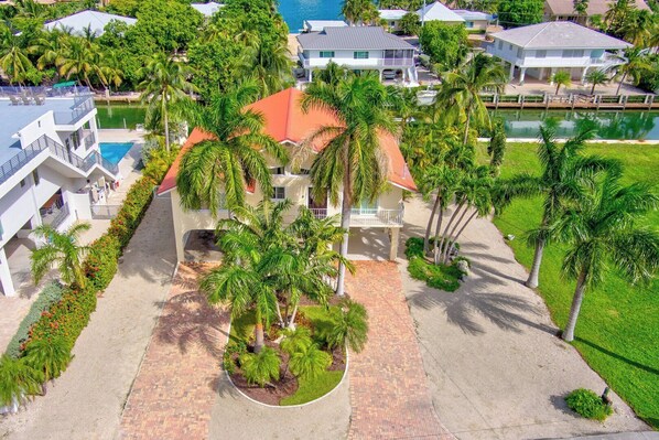 Un resort con piscina, palmeras y vista al mar.