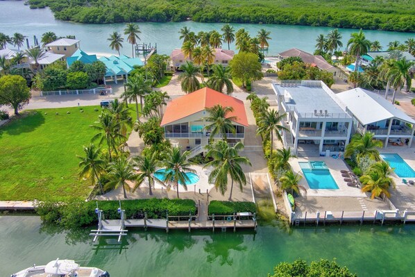 A resort with multiple buildings, a swimming pool, and a dock.