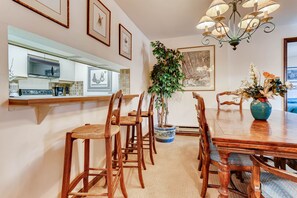Enjoy meals in this inviting dining area with a traditional table, comfortable chairs, and a beautiful potted plant.