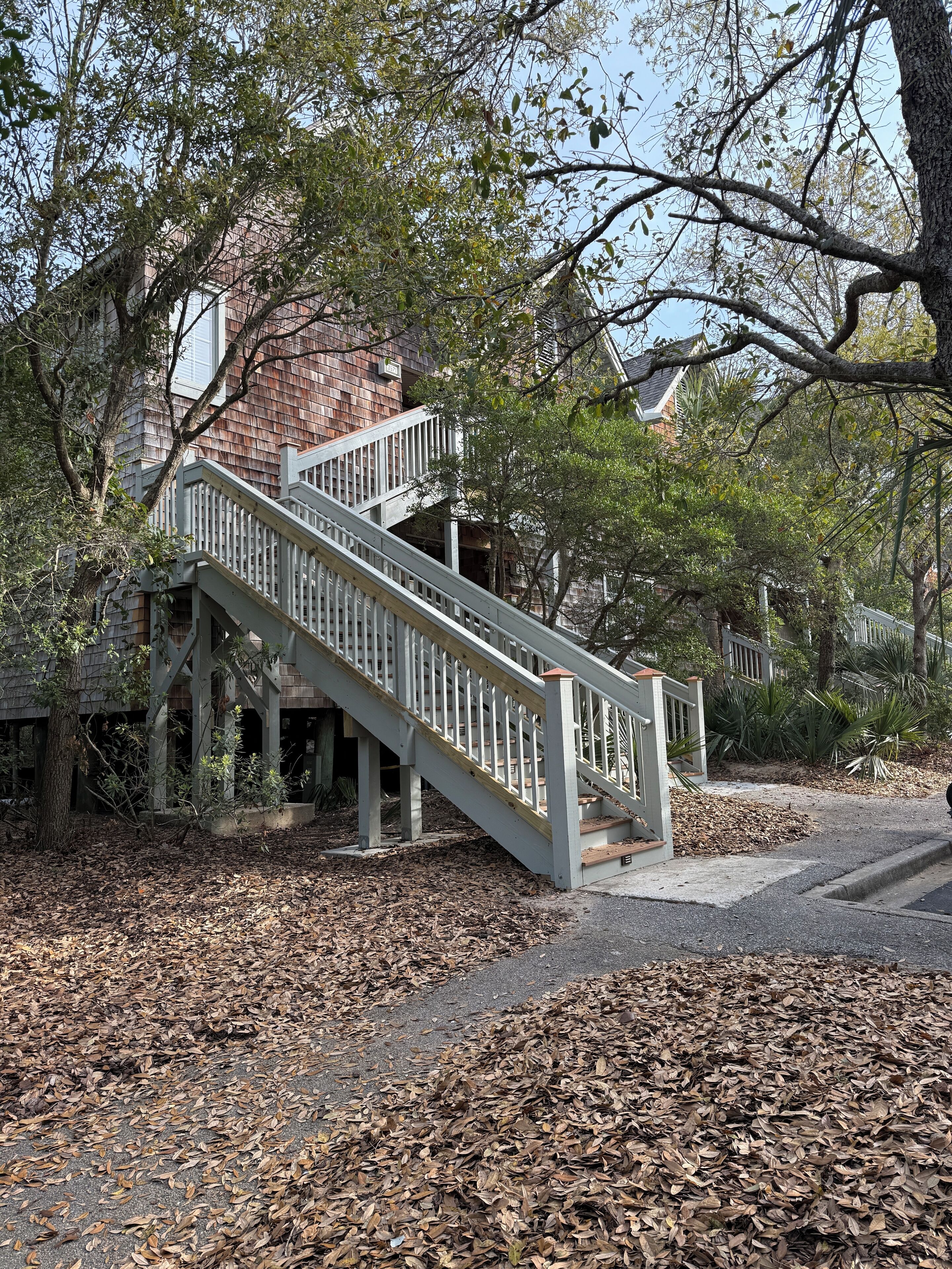 A wooden staircase leading up to a house with a brick facade.