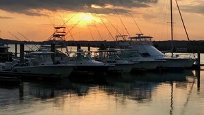 Un puerto deportivo con barcos amarrados al muelle al atardecer.