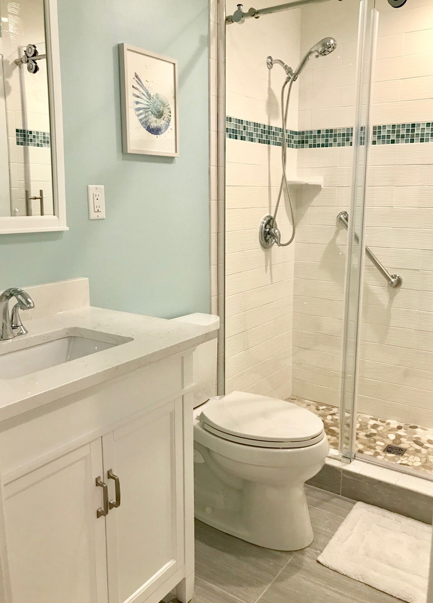 A bathroom with a white sink, toilet, and shower.