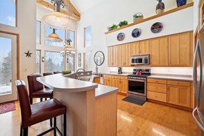 Enjoy cooking in this well-lit kitchen with a central island and seating, stainless steel oven, and microwave.