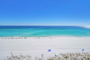 A beach with a clear sky, a sandy shore, and a calm sea. - Gulf Front! Beach Service Included! Sea Dunes 604! (Fort Walton Beach)