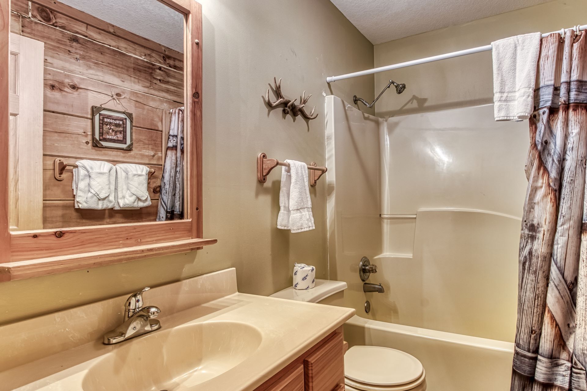 A bathroom with a wooden vanity, a bathtub, and a shower.