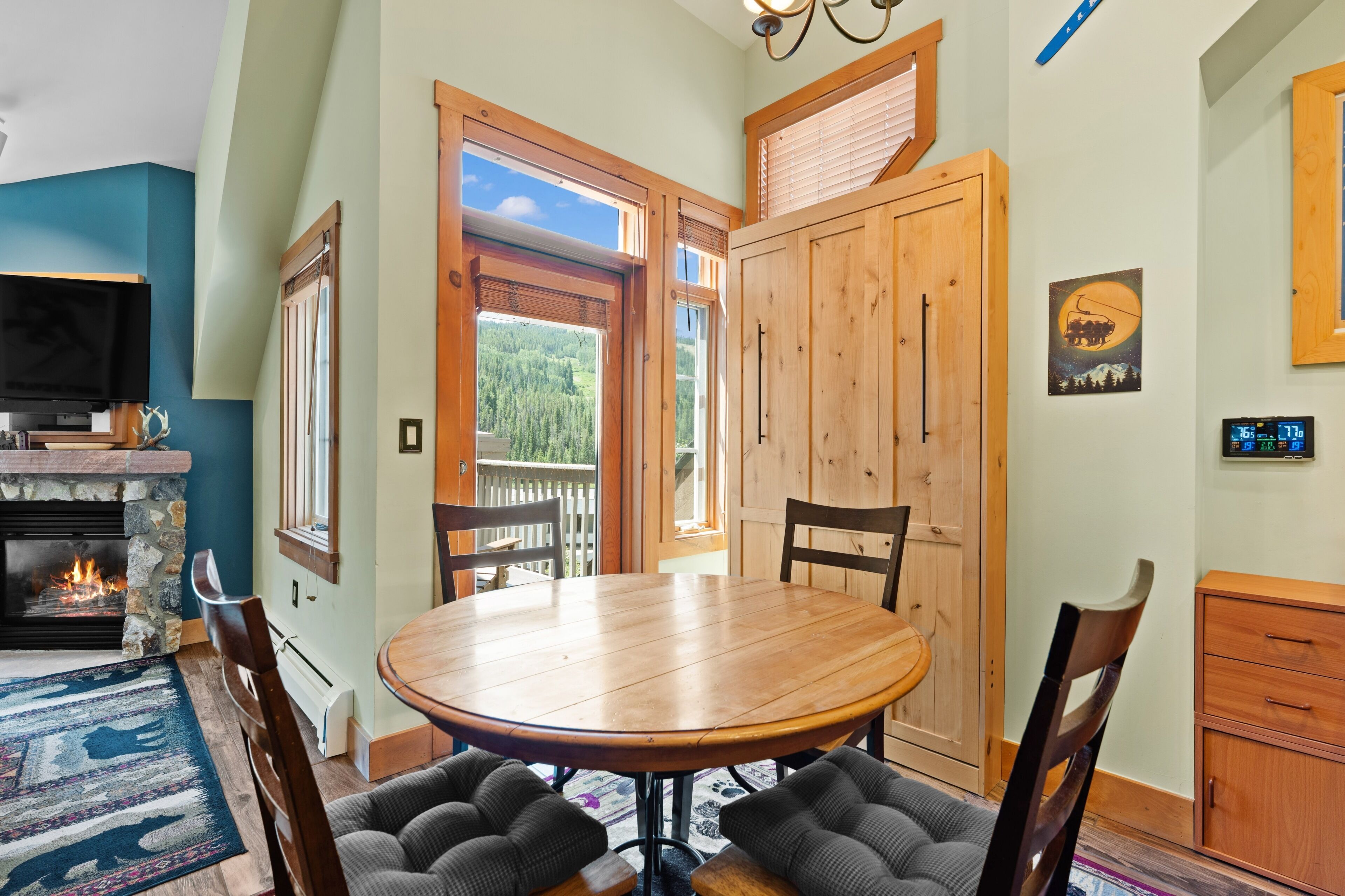 Un coin repas chaleureux avec une table ronde en bois, des chaises rembourrées et une cheminée.