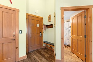 A hallway with wooden doors, a bench, and a ski rental sign.