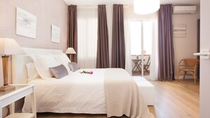 Une chambre bien rangée, avec un lit, des tables de chevet, une chaise et une fenêtre avec des rideaux.
