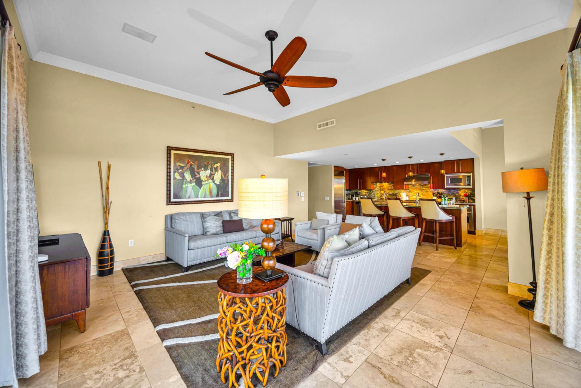 A spacious living area with a sofa, coffee table, and a dining area with bar stools.
