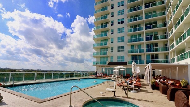 A rooftop pool area with a hot tub, lounge chairs, and a view of the ocean. - Adorable 12th Floor Standard Unit-Parking Included (Miami)