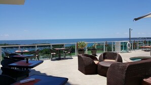 A terrace with wicker furniture, a pool, and a view of the sea. - Adorable 12th Floor Standard Unit-Parking Included (Miami)