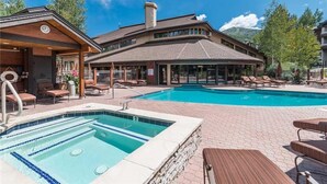 Ein Hotel mit Pool, Liegestühlen und einem überdachten Bereich mit Holzterrasse.