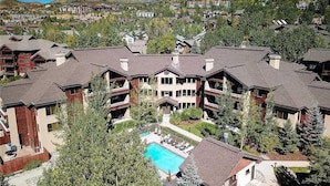 Ein Resort mit mehreren Gebäuden, einem zentral gelegenen Pool und umgebender Bepflanzung.