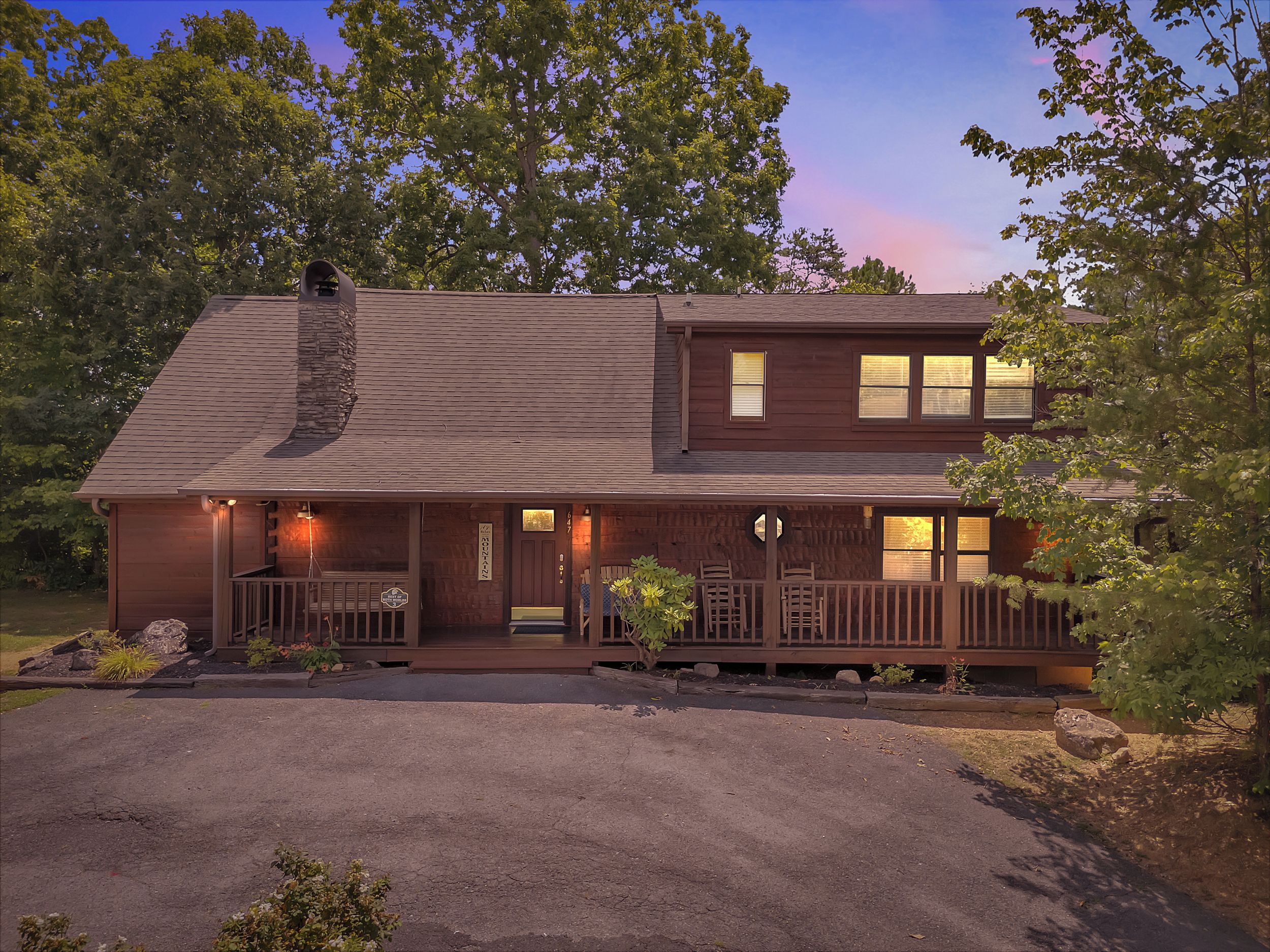 A two-story wooden house with a porch, a chimney, and a well-maintained lawn.