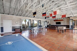 Amplio espacio interior con mesa de ping pong, mesa de fútbol y mesa de billar.