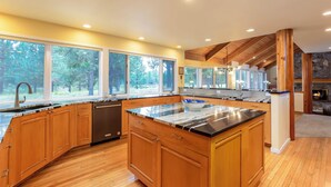 Una cucina moderna con mobili in legno, un'isola grande e una parete decorata con pietra.