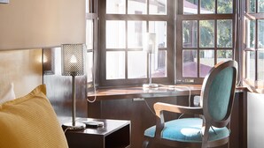 A hotel room with a bed, a desk, a chair, and a large window with a view of buildings and trees. - Hotel BY Armonia SCZ (Santa Cruz)