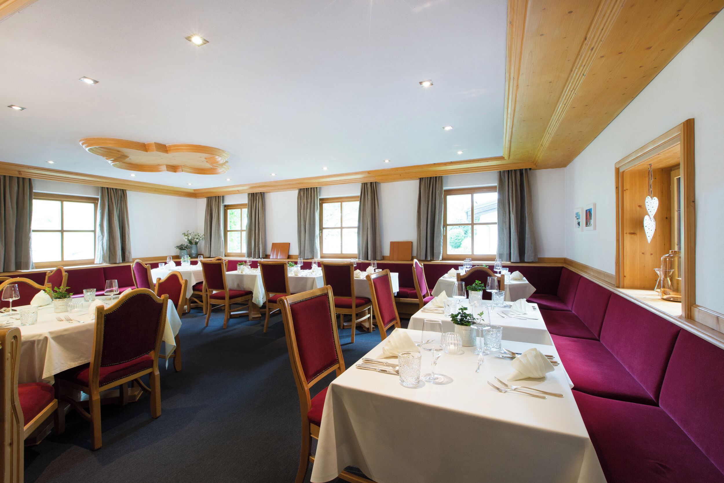 A restaurant with multiple tables and booths, arranged in a spacious layout with natural light from large windows.