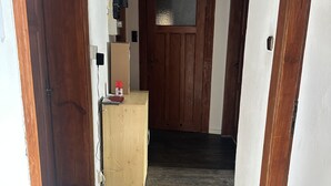A hallway with wooden doors, a small wooden desk, and a dark wooden floor. - Sultanias Homesharing (Nuremberg)