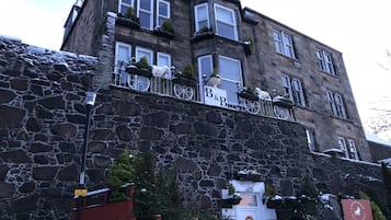 A stone building with multiple windows and a sign that reads "B&B".