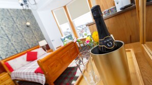 A room with a bed, a wooden dresser, a small table with a bottle of champagne and two glasses, and a window with a view. - Castle Walk B&B (Stirling)