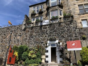 Un edificio de piedra con un letrero que dice 'Bed & Breakfast' y un letrero que indica 'Castle Walk'.
