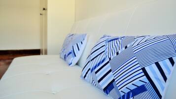 Un sofá blanco con almohadones a rayas.