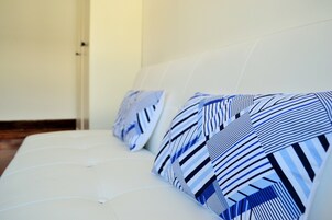 Un sofá blanco con almohadones a rayas.