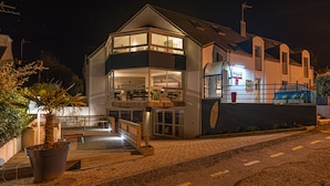 Un bâtiment moderne à deux étages, doté d’un balcon, de grandes fenêtres et d’une enseigne de restaurant bien visible.