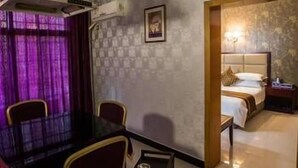 Et hotelværelse med spiseplads, en seng med gavl og et lille bord.
