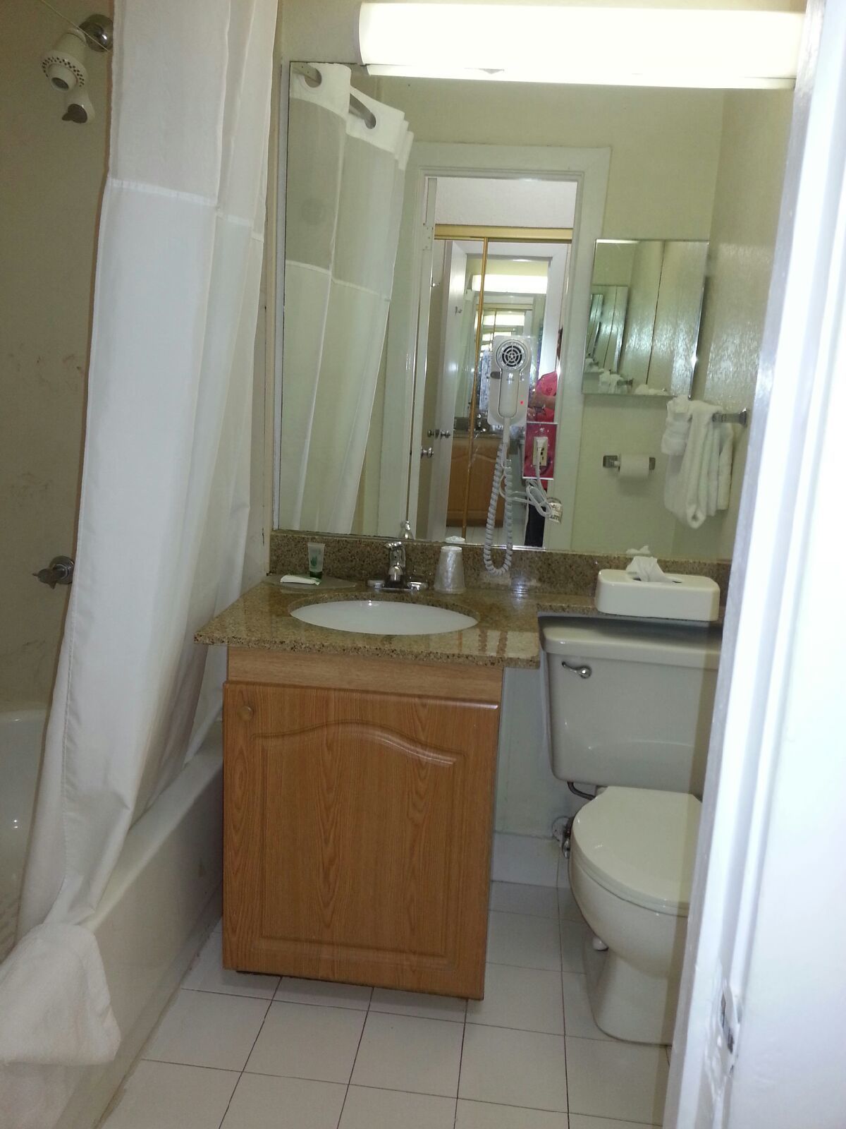 Un baño con ducha, lavabo, inodoro y espejo.