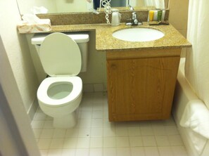 Une salle de bain avec des toilettes, un lavabo et un meuble en bois.