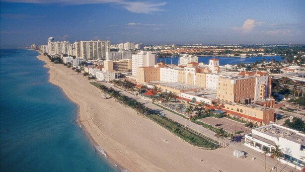 An aerial view of a coastal city with a long beachfront, high-rise hotels, and a marina. - Hollywood Beach Resort - Renovated Large Studio (Hollywood)