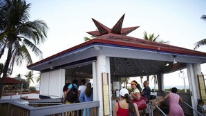 A covered outdoor area with a star-shaped roof, a railing, and a sign indicating no smoking.