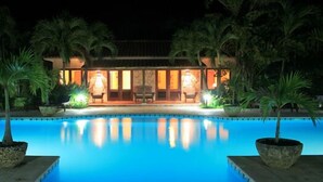A nighttime view of a swimming pool with a building in the background. - Family Oriented - Private Beach & Horse Stables - Ocean, Pool, & Hot Tub (Cabrera)